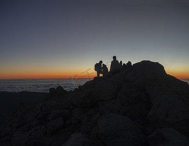 日出前的红光在 pico del teide vulcano 西班牙最高山的顶部，徒步旅行者的轮廓在特内里费岛加那利岛上等待日出