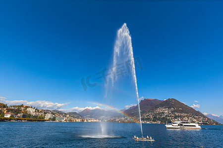 卢加诺湖和带喷泉和彩虹的城市全景