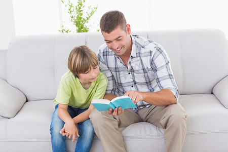 爸爸在沙发上给男孩读故事