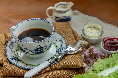 黑咖啡加牛奶在麻袋布上新的早晨。