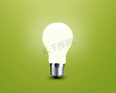 电灯泡摄影照片_在绿色背景的发光的电灯泡想法