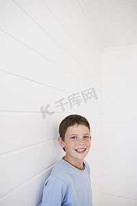 站在挡风雨墙上的快乐小男孩的画像