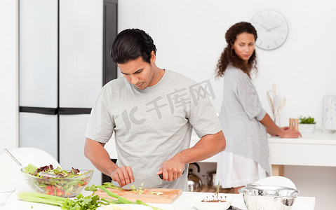 专注的男人和他的女朋友一起切菜