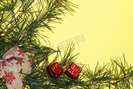 新年黄色背景上的针叶树枝和圣诞树装饰，复制空间