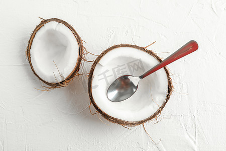 文字碎片摄影照片_白色背景上带勺子的半个椰子，文字空间