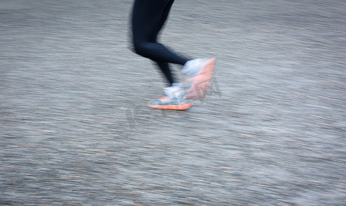 跑步中的人摄影照片_运动模糊城市环境中跑步者的脚（平移技术