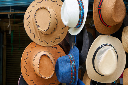 在街头市场购买各种款式的帽子。