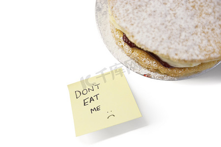 吃我摄影照片_一块维多利亚海绵蛋糕，在便利贴上写着“不要吃我”