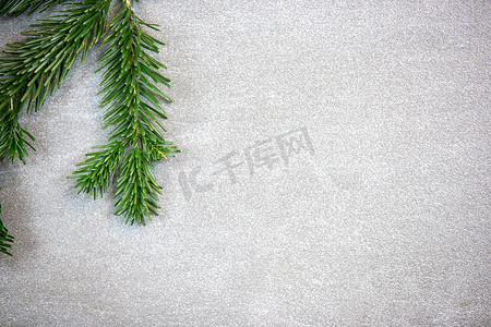 圣诞主题、纹理、背景与诺德曼冷杉的树枝留在顶部的深灰色大理石背景上，带有文本的可用空间。