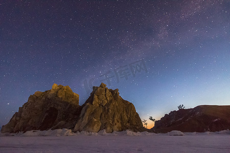 Shamanka 岩石在冬天的夜晚、银河和黎明的迹象。 