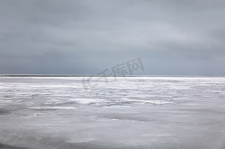 结冰的海水和地平线上的灰色天空