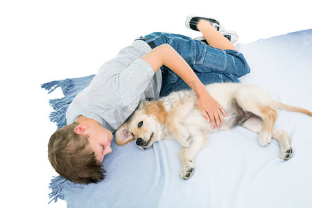 男孩和小狗躺在白色背景的毯子上