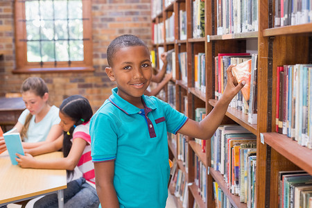可爱的小学生在图书馆找书