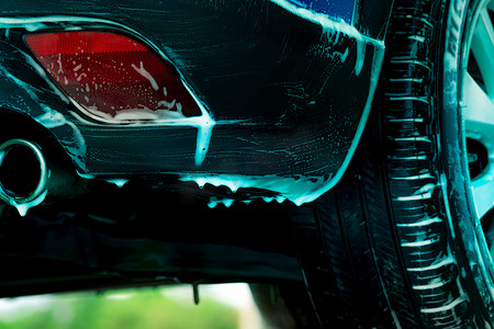 Suv摄影照片_特写镜头蓝色 SUV 洗车用白色肥皂泡沫。