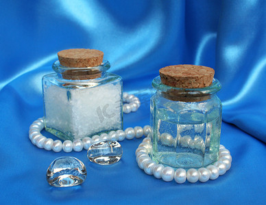 丝绸制作摄影照片_蓝色丝绸上带有白色珍珠的 Spa 组合物