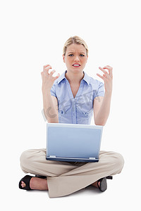 坐着的女人对她的笔记本电脑很生气