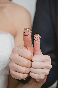 他们手指上的结婚戒指上画着新娘和新郎，有趣的小人物
