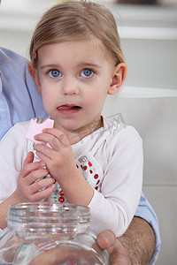 eva减震棉摄影照片_一个小女孩在她父亲的怀里吃着棉花糖。