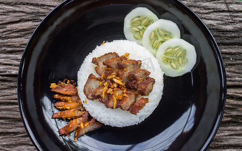泰国菜炒猪肉配大蒜和黄瓜在黑盘平