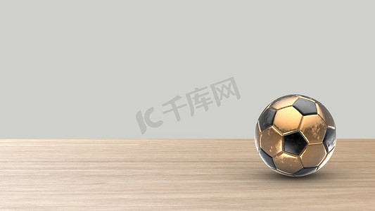 金黄足球金属球 在木桌上的橄榄球有白色灰色背景。 