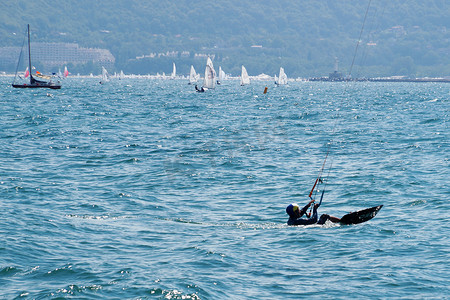 一个男人在晴朗多风的日子里在海上放风筝。
