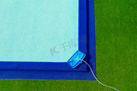 泳池的顶视图摄影照片_泳池边缘的顶视图清洁网是绿色和蓝色的