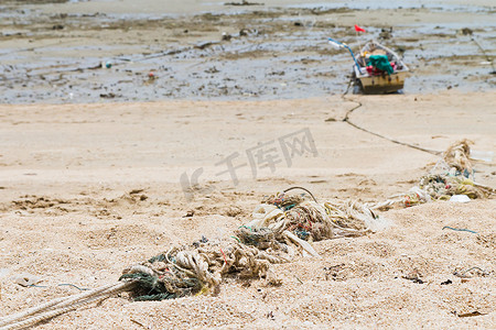 绳子绑在海滩上的一艘渔船上。