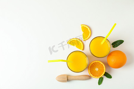卡通榨汁机摄影照片_平铺组合物，包括新鲜橙汁、木制榨汁机、薄荷、橙子和木制榨汁机，白色背景、顶视图和文字空间。