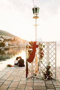 婚礼屏风矗立在码头上，背景是新郎新娘拥抱