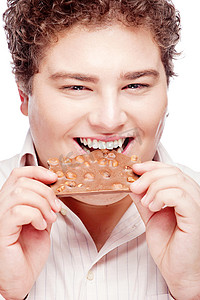 快乐的胖乎乎的年轻人吃着一块巧克力