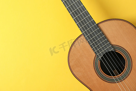 黄色背景中漂亮的古典吉他，文字空间