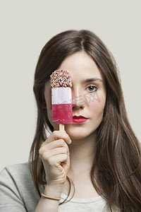 灰色背景下红唇拿着冰淇淋棒的年轻女子画像