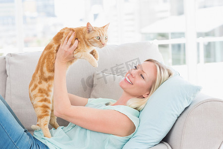 在家沙发上举猫的女人