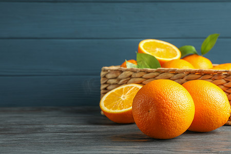 木桌上放着熟橙子的柳条篮，文字空间