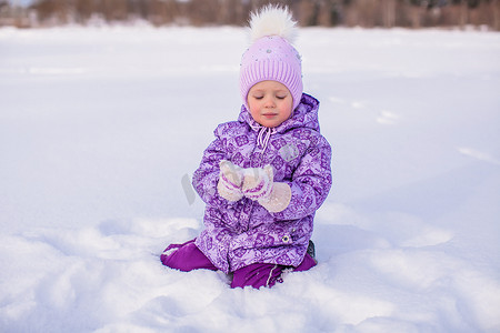 快乐的小女孩在冬天阳光明媚的日子里玩雪