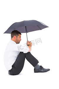 拿着黑伞坐在地板上的商人