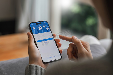 手机登录背景摄影照片_泰国清迈 - 2023 年 4 月 16 日：Facebook 社交媒体应用程序徽标登录、iPhone 14 移动应用程序屏幕上的注册页面亲自从事电子商务购物业务