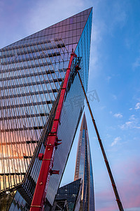 俄罗斯，圣彼得堡，2020 年 7 月 3 日：日落时拉赫塔中心摩天大楼的彩色图像，建筑物玻璃立面上日落天空的反射，施工竣工，巨大的起重机