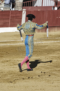 西班牙斗牛士，手上有两面白蓝手旗，在乌贝达的斗牛场呼唤公牛钉他们