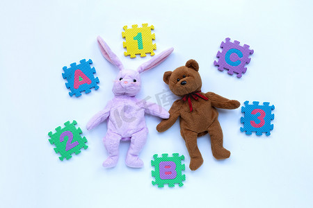 带英文字母拼图和数字的兔子玩具和泰迪熊
