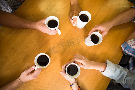 双手捧着桌上的咖啡杯