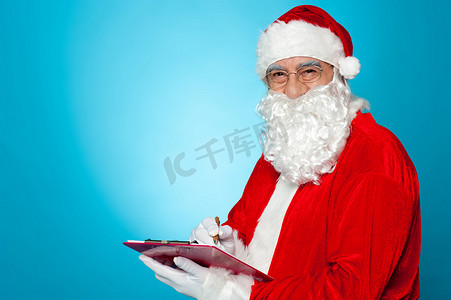一个彻底现代的圣诞老人检查他在剪贴板上的列表