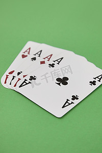 绿色表面上的四个 ace 扑克牌