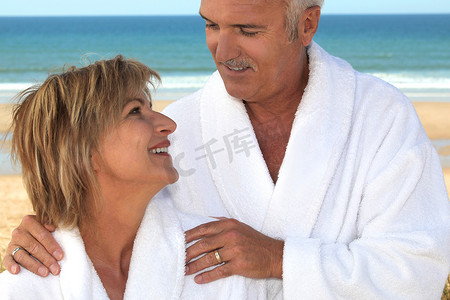 在海滩上穿着浴袍的情侣。