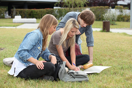 三个学生在草地上学习
