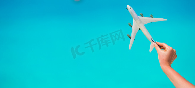 绿松石海女性手背景中的小白飞机模型