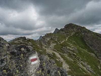 红色步道标牌位于罗哈斯山脊陡峭的远足小路上，通往奥斯特里罗哈克峰。