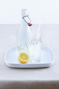 瓷瓶摄影照片_陶瓷瓶柠檬水玻璃和托盘上的柠檬