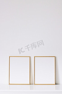白色家具上的两个金色垂直框架、豪华家居装饰和模型创作设计