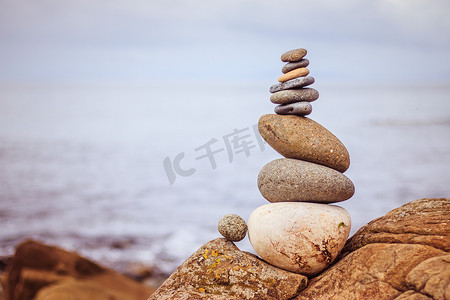 平衡、放松和健康：外面的石冢，模糊背景中的海洋